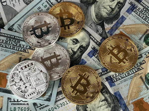 Cryptocurrency coins on US dollar bills representing exchange rate calculation